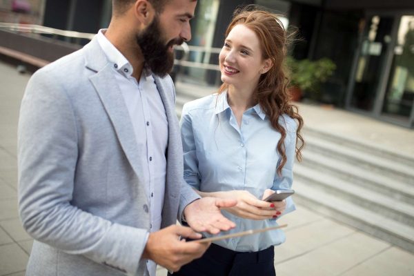 smiling-business-man-and-woman-chatting-outdoor-M5EHGAQ.jpg