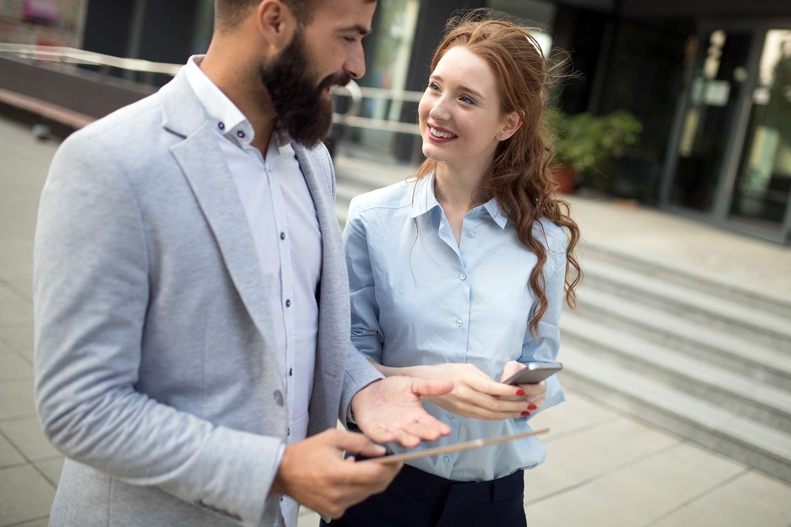 smiling-business-man-and-woman-chatting-outdoor-M5EHGAQ.jpg